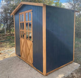 Antrasit dış yüzeyli, kapılı ve camlı ahşap ardiye kulübesinin sol yan cepheden görüntüsü.